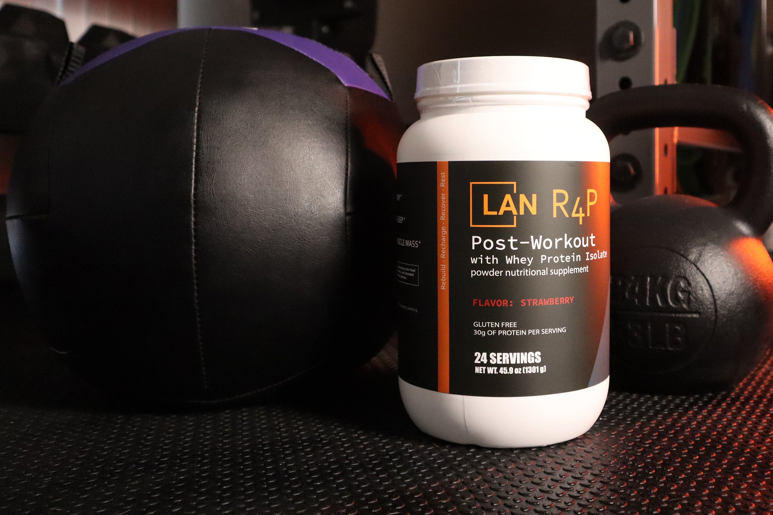 R4P Post-Workout 30g Grass Fed Whey Protein Isolate with magnesium and aminos next to kettlebell